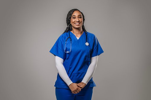 A newly settled GP in blue scrubs with a stethoscope