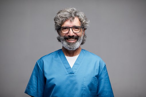 An experienced doctor in blue scrubs