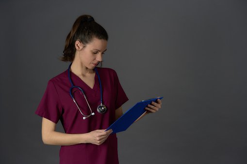 A clinician with a clipboard checking paperwork