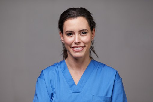 A clinician smiling warmly at work