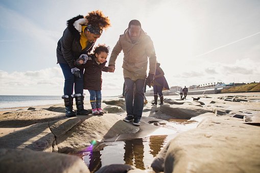 A family exploring rock pools by the sea